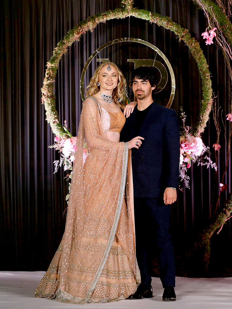 Mandatory Credit: Photo by Altaf Qadri/AP/REX/Shutterstock (10013599o) Joe Jonas, Sophie Turner. Joe Jonas and his fiancé and Game of Thrones actress Sophie Turner pose for photographs during the wedding reception of Bollywood actress Priyanka Chopra and musician Nick Jonas in New Delhi, India Chopra Jonas Wedding, New Delhi, India - 04 Dec 2018